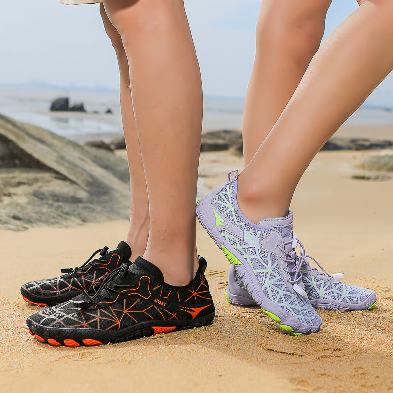 Two pairs of shoes on feet standing on sand with a beach background