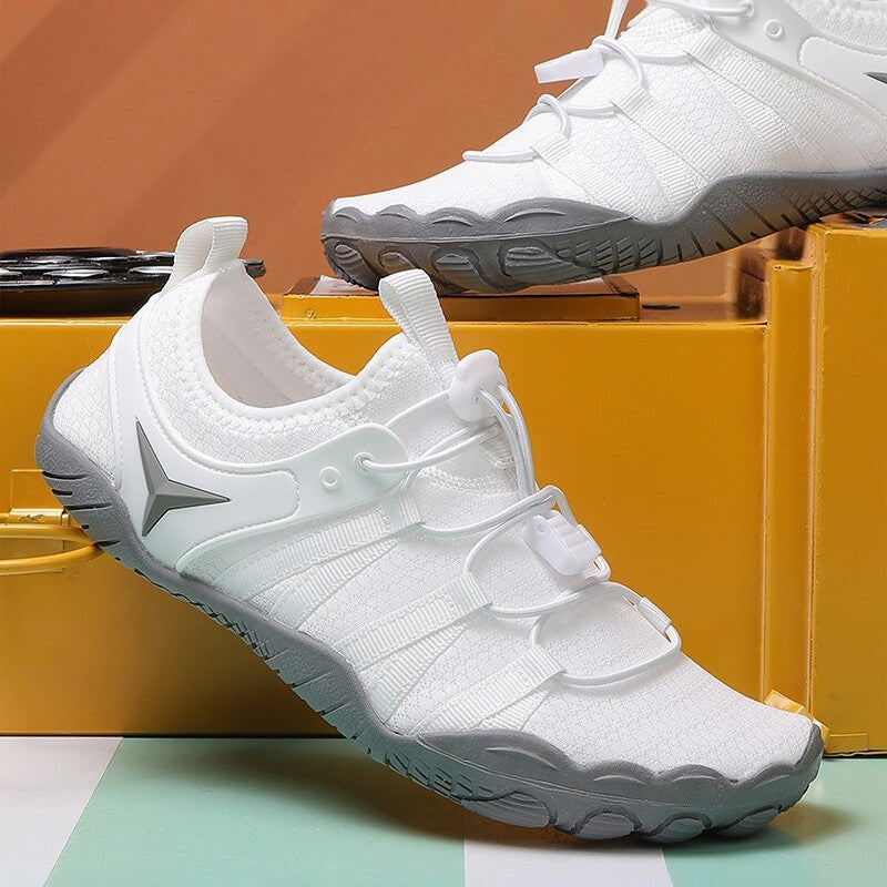 White athletic shoes with gray soles on a colorful geometric background