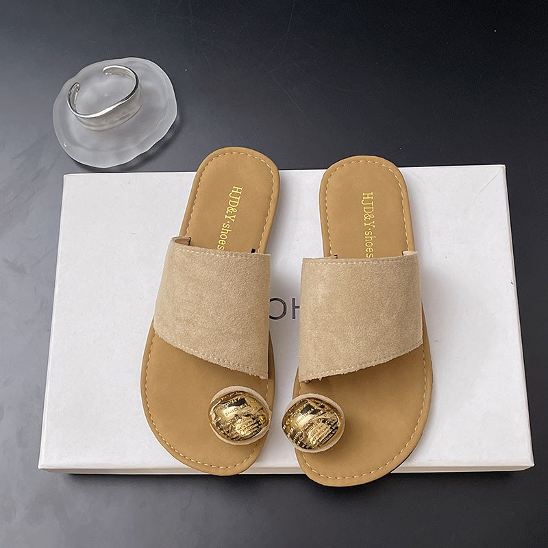 Pair of beige sandals with gold accents on a white box with 'Hush Puppies' branding.