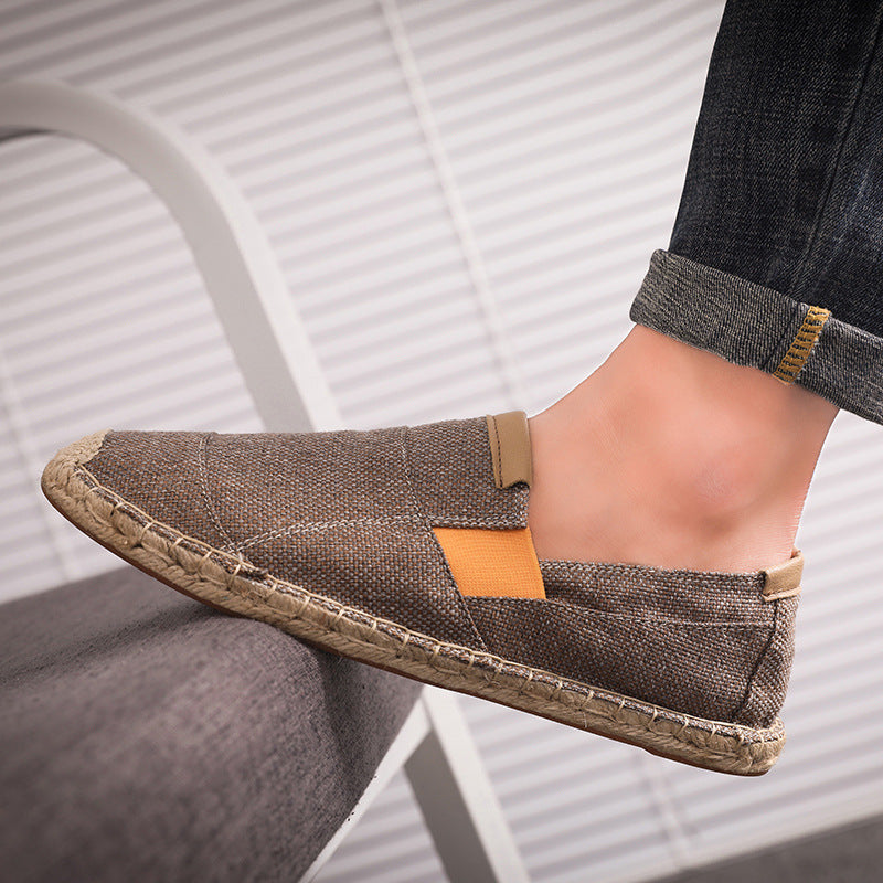 Brown espadrille shoe worn by a person sitting on a chair.