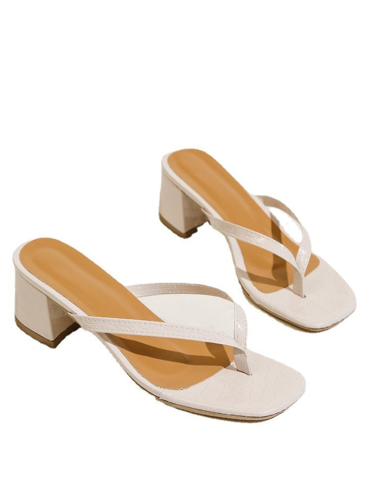 Pair of white sandals with tan soles on a white background