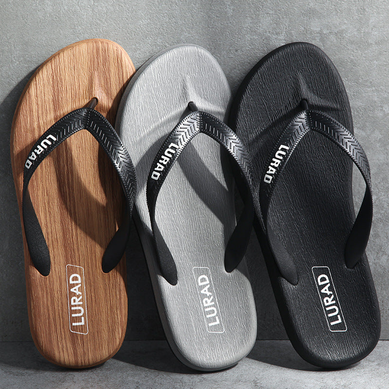 Three pairs of LURAD flip-flops in brown, gray, and black on a gray background