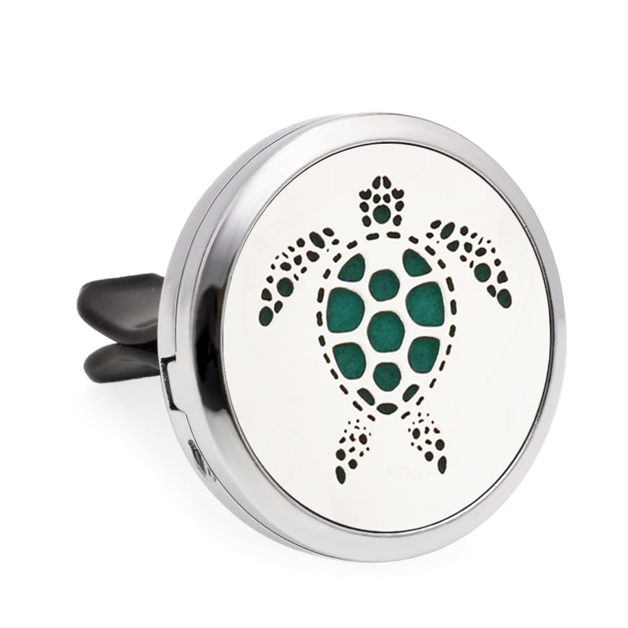 Round silver diffuser with green turtle design on a white background