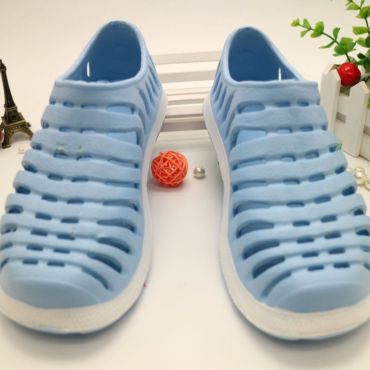 Pair of blue sandals with white soles on a light background