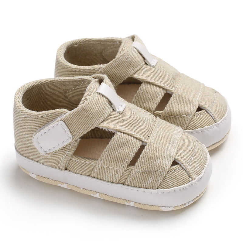 Beige baby sandals with white soles on a white background