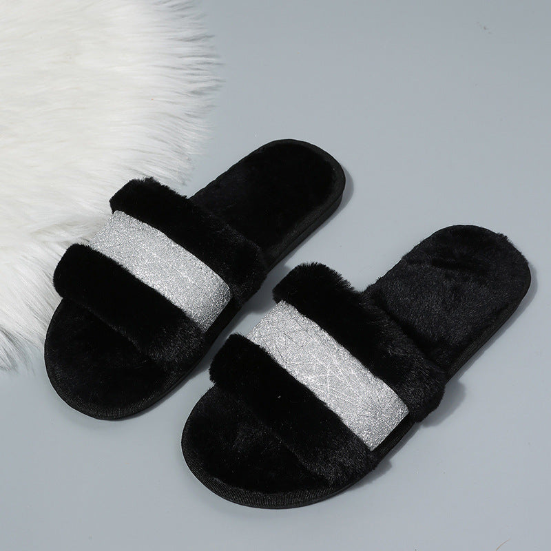 Black slippers with a silver glittery band on a light gray background