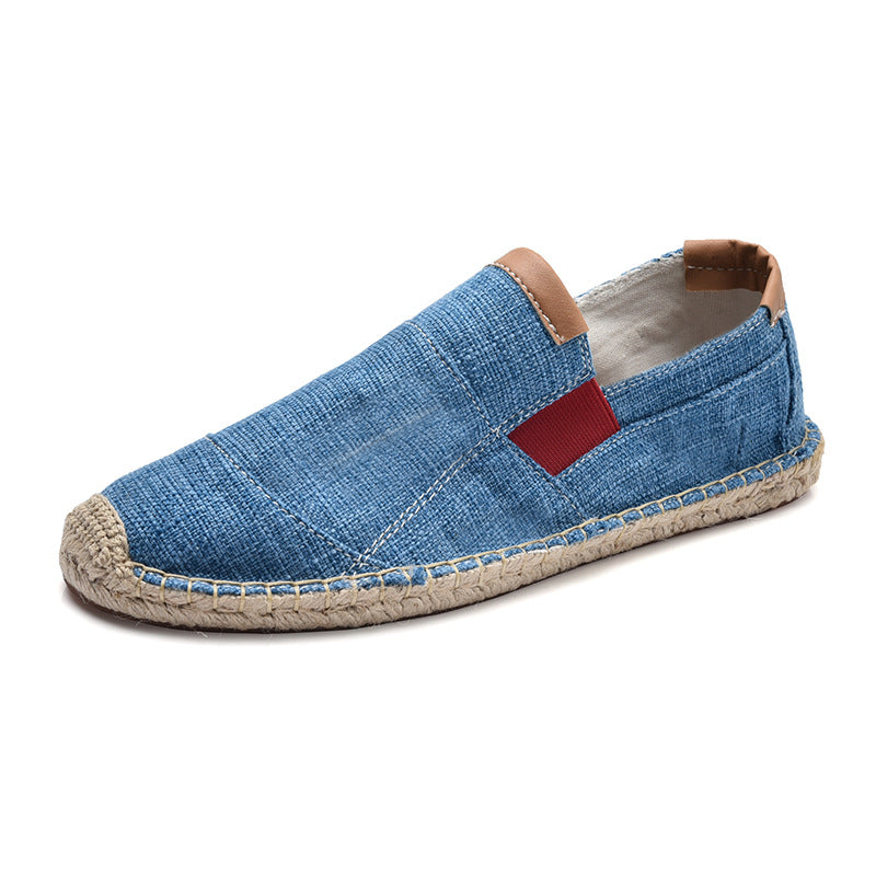 Blue espadrille shoe with a red label on a white background