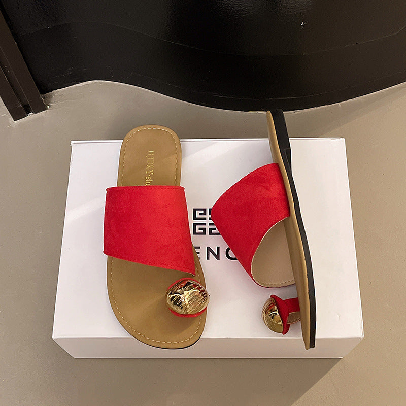 Red sandals with gold accents on a white box