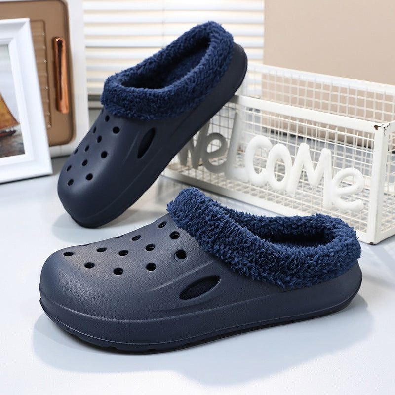 Pair of navy blue clogs with fuzzy trim on a light surface.