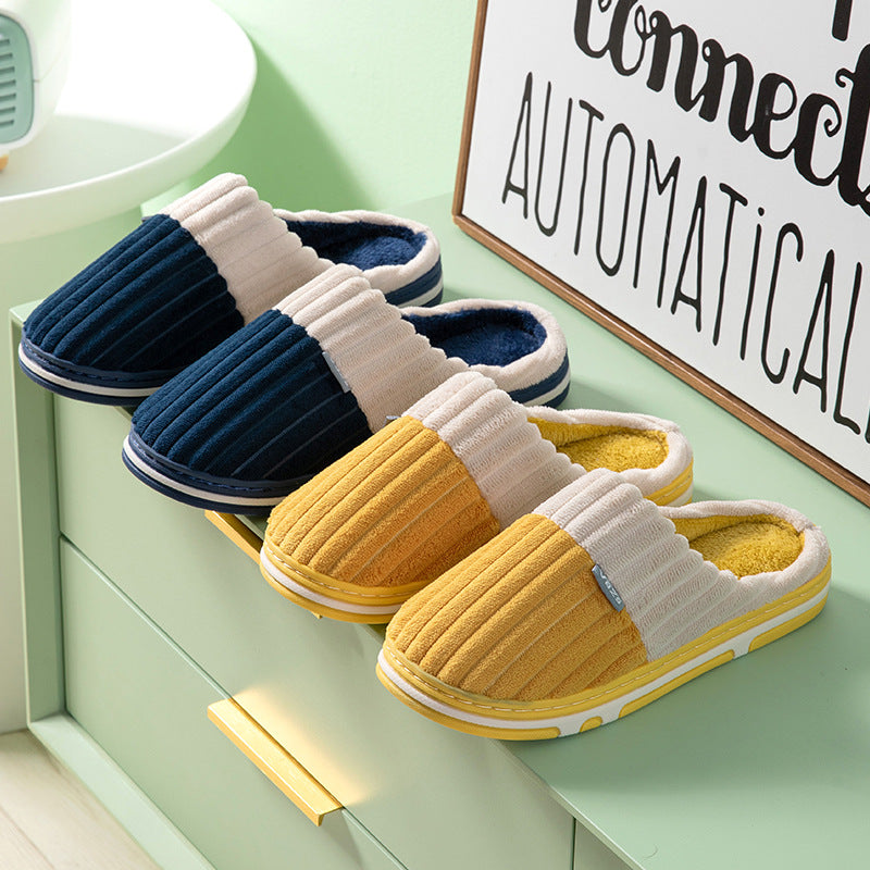 Pair of blue and yellow slippers on a green surface with a sign in the background.