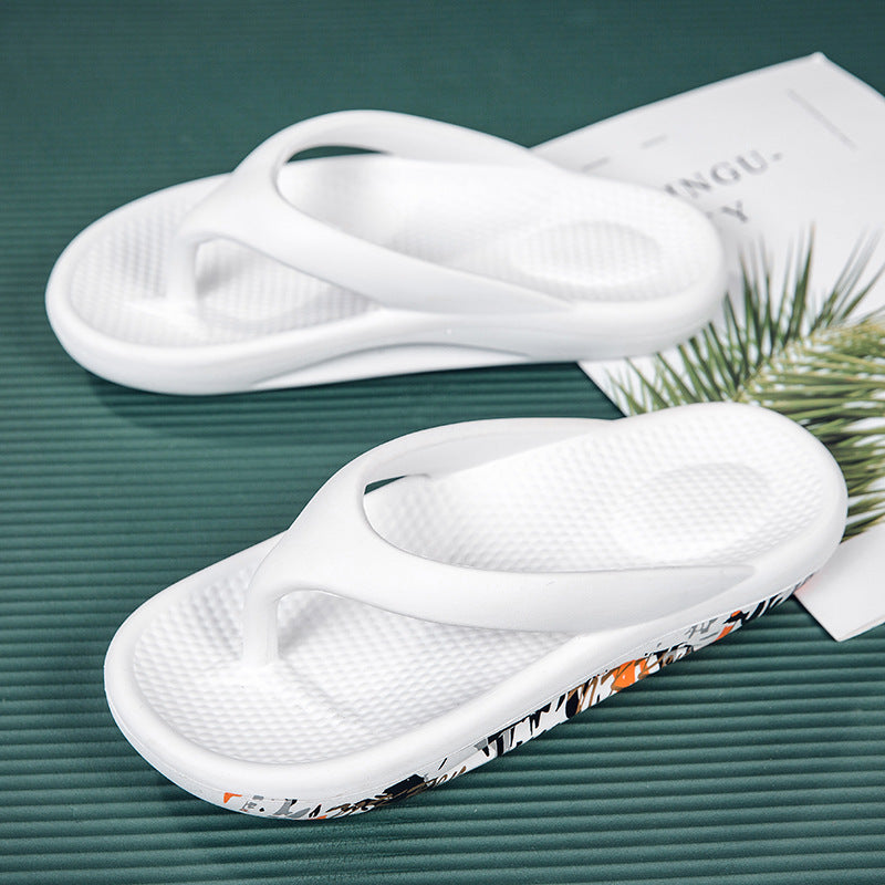 White slippers with a patterned sole on a green surface