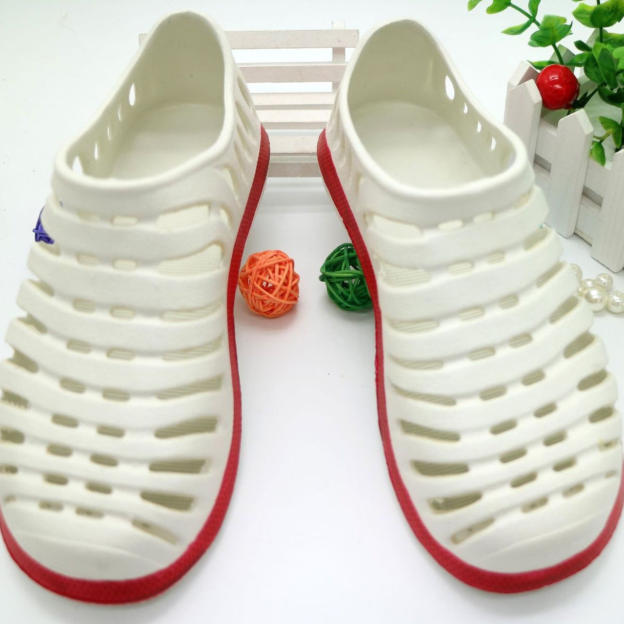 White sandals with red soles on a white background