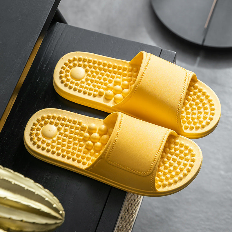 Yellow slippers with textured sole on a dark surface