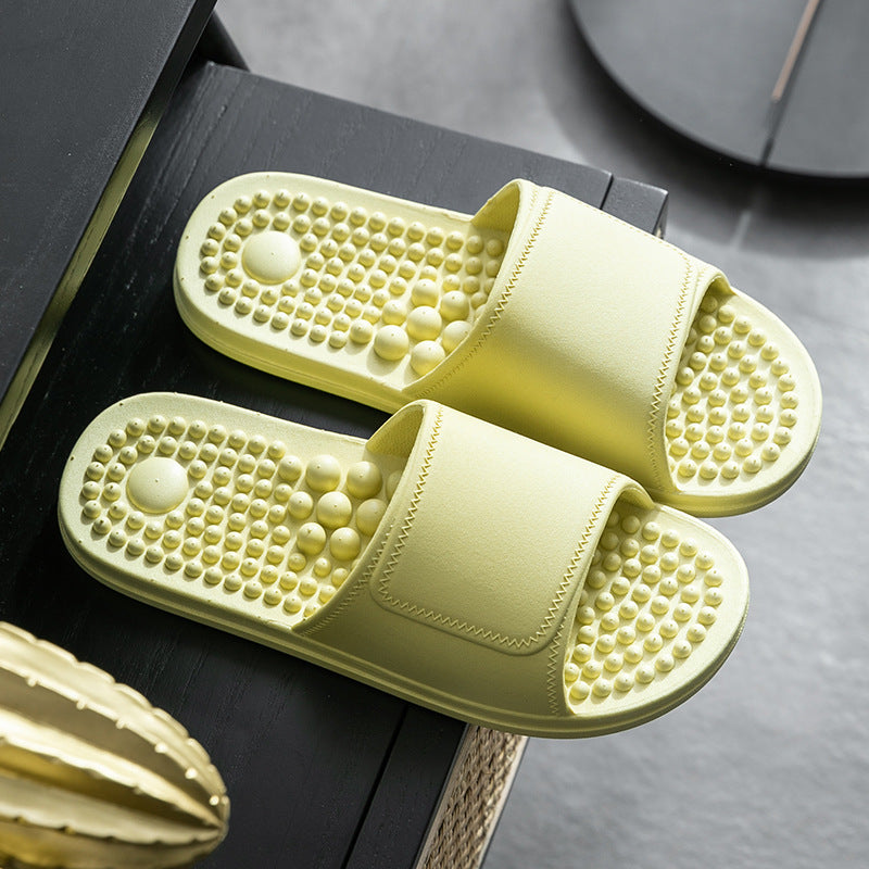 Pair of yellow slippers with textured sole on a dark surface