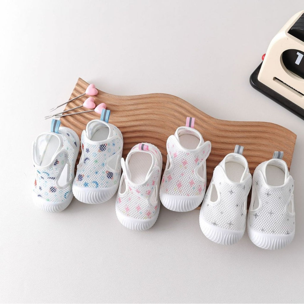 Set of baby shoes on a wooden board with a white background