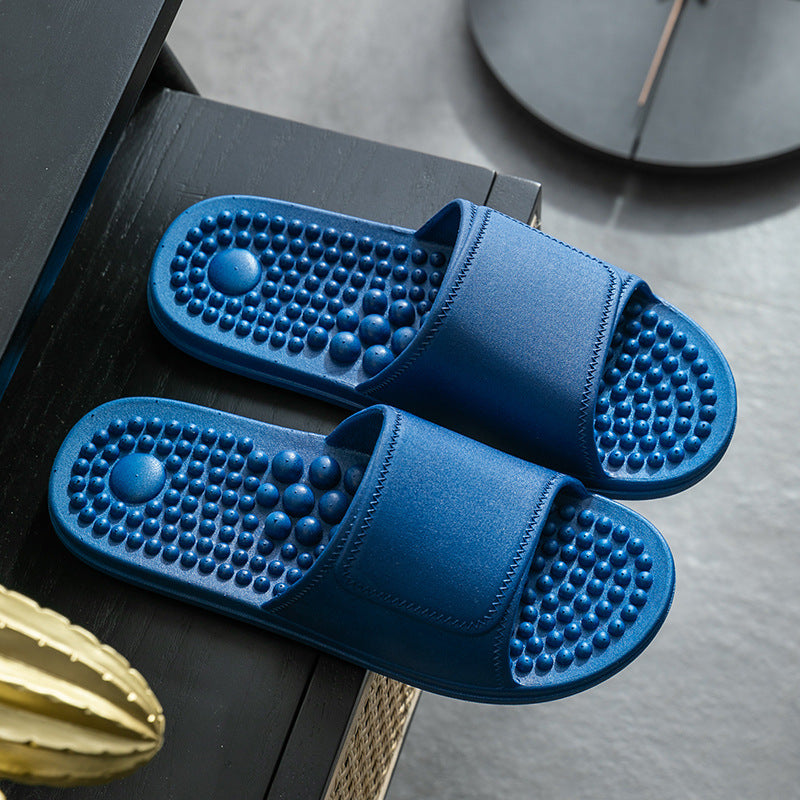 Blue massage slippers on a wooden surface with a clock in the background