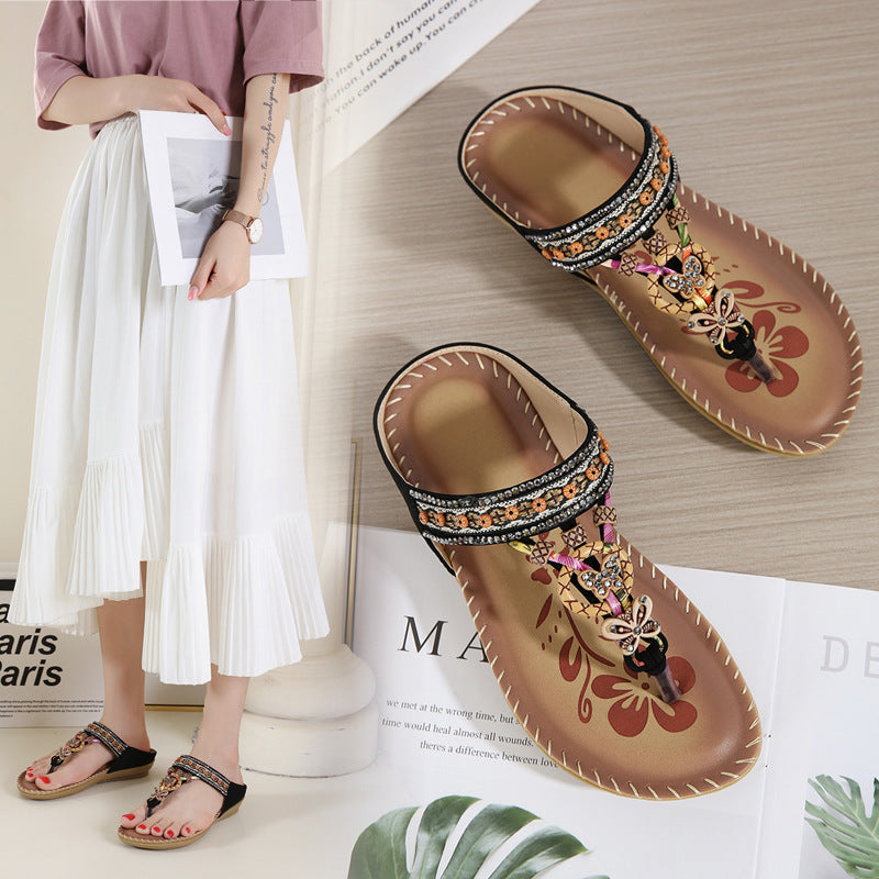 Decorative sandals with embellishments on a wooden surface with a magazine underneath.