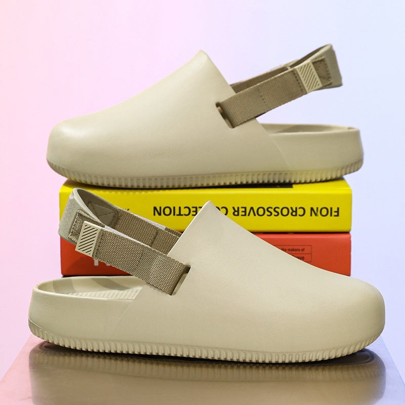 Beige clogs with strap on a reflective surface with books in the background