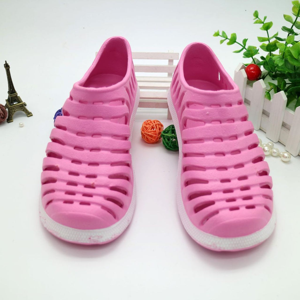 Pair of pink sandals on a white surface with decorative elements.