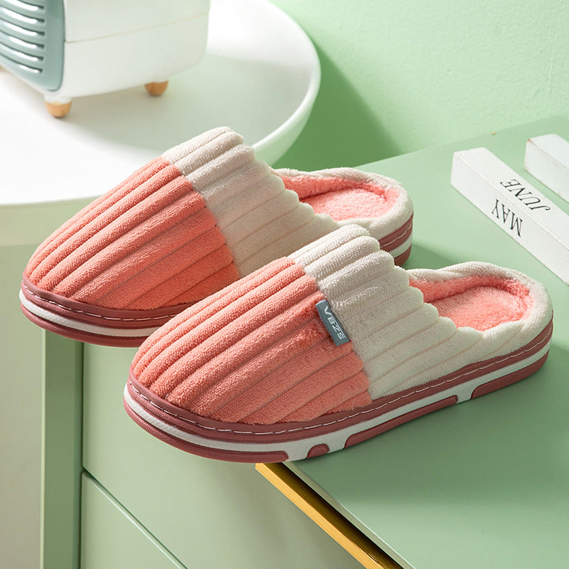 Pair of pink and white slippers on a green surface with a blurred background