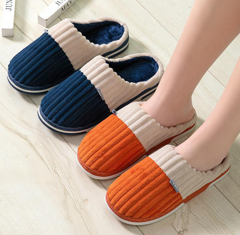 Pair of blue and orange slippers on a light wooden floor.