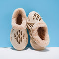 Pair of beige slippers with fluffy texture on a blue background