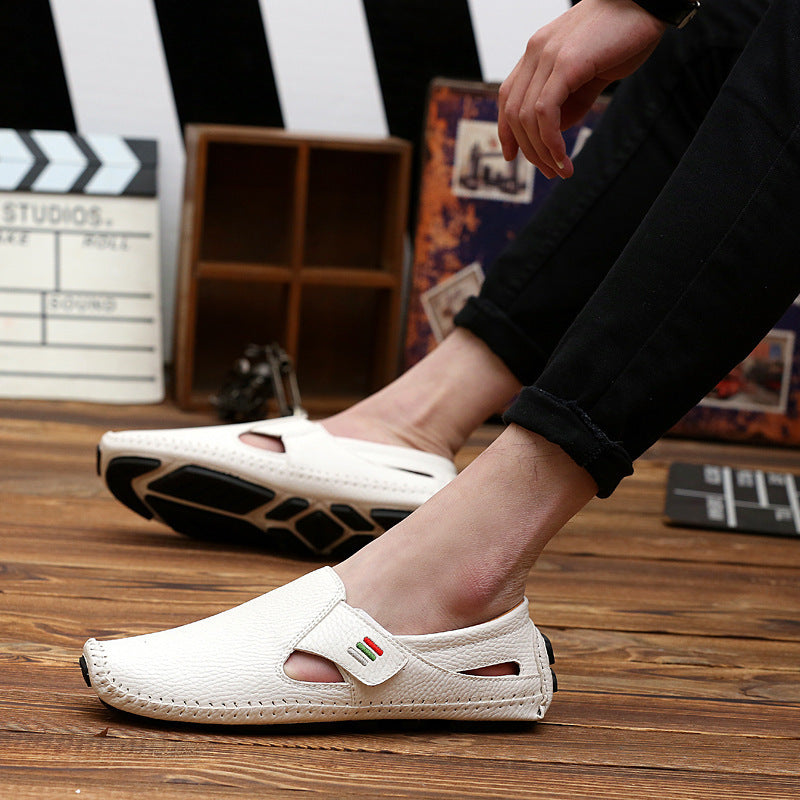 White sandals worn by a person on a wooden floor with a film studio background.