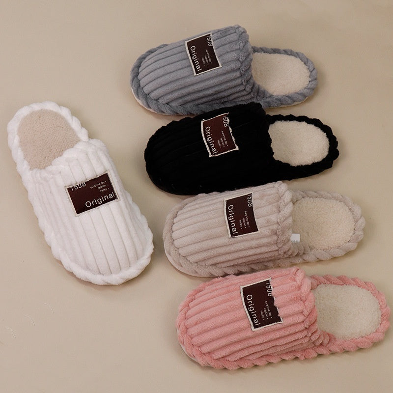 Set of five pairs of slippers in gray, black, white, pink, and beige on a beige background.