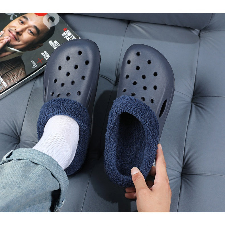 Blue slippers with fuzzy lining worn by a person on a gray couch.