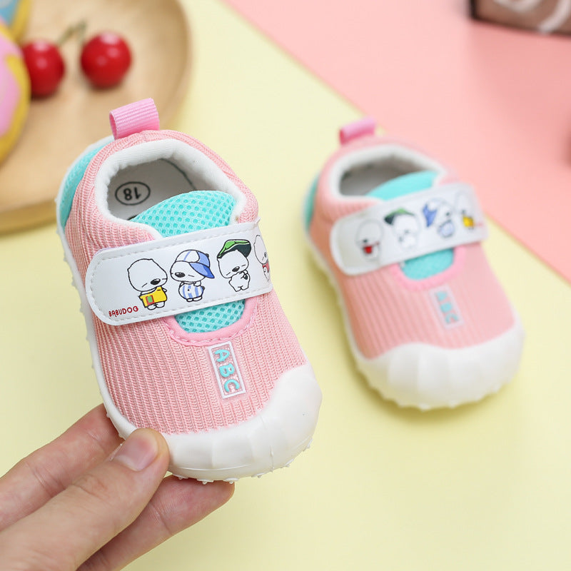 Pink baby shoes with cartoon characters on a colorful background