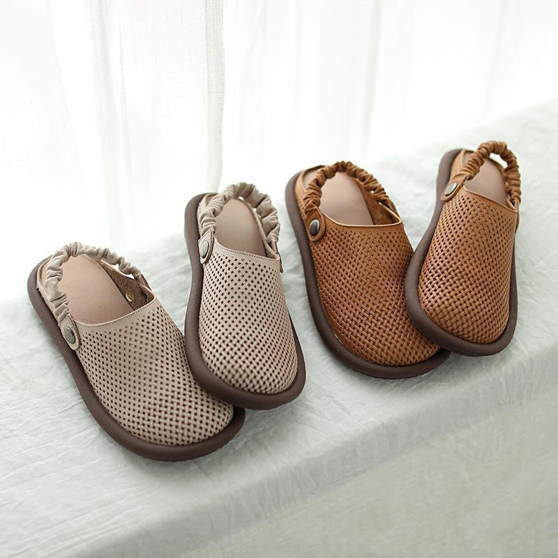 Pair of brown and beige slippers on a white surface