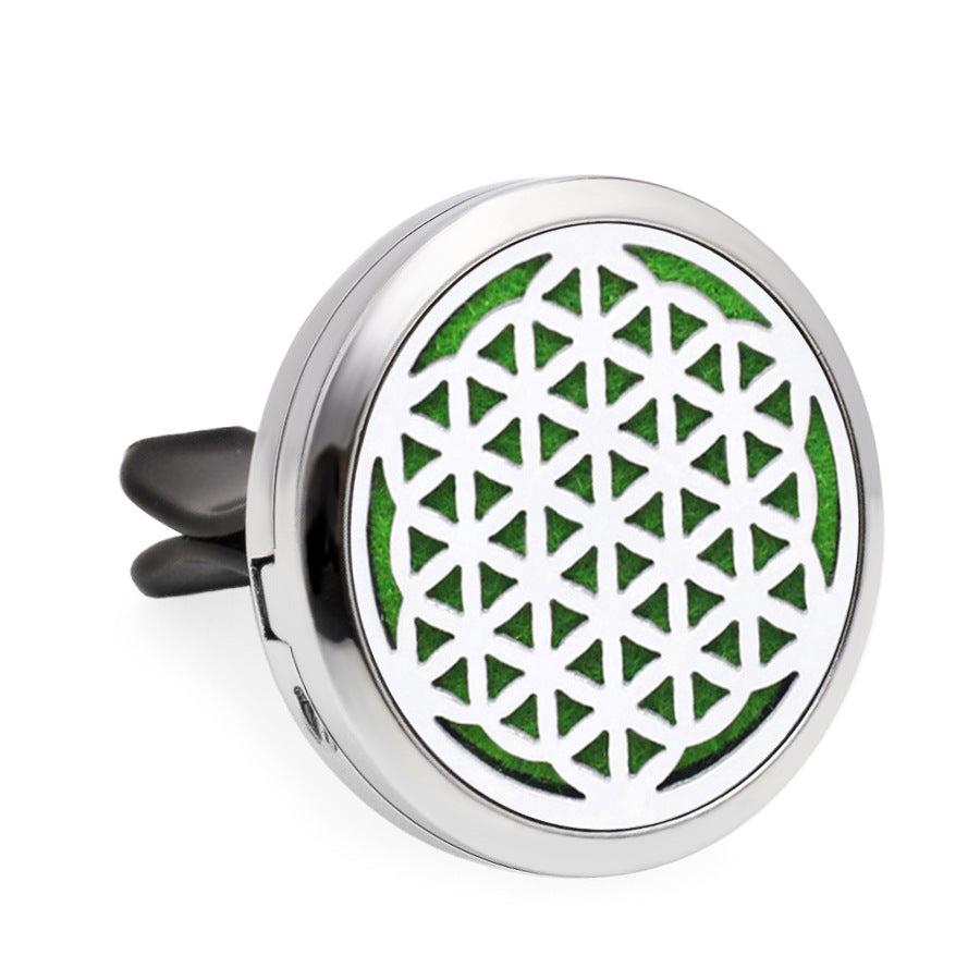 Round metallic diffuser with green geometric pattern on a white background