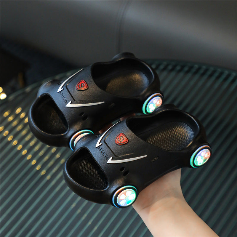 Black slippers with colorful lights on a textured surface