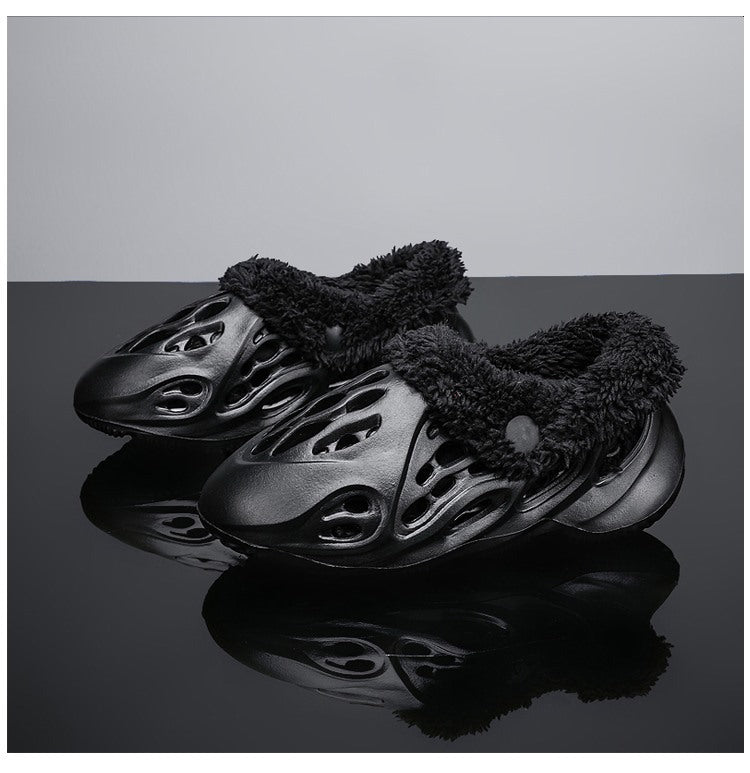 Black slip-on shoes with fuzzy texture on a reflective surface with a gradient background