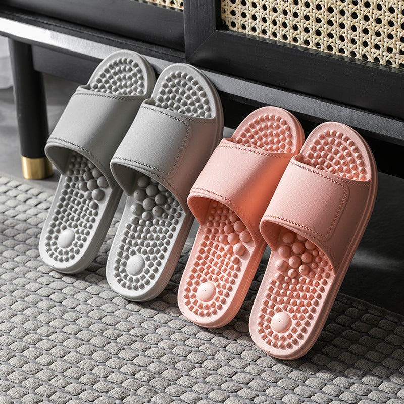 Pair of gray slides and pink slides on a textured surface.