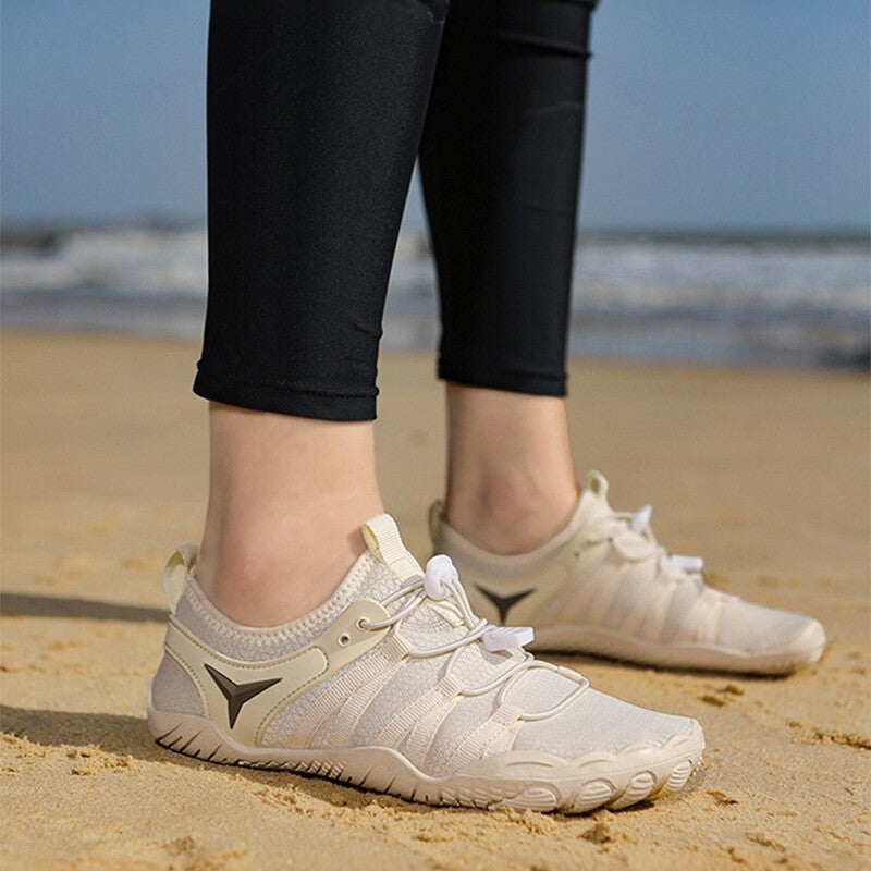 White sneakers on a sandy beach with a blurred ocean background
