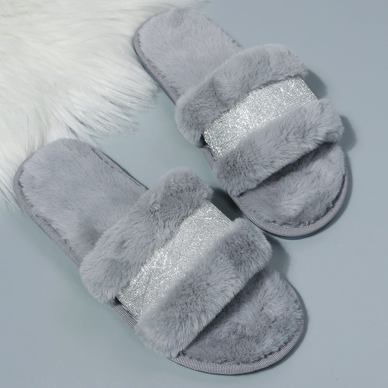 Gray fluffy slippers with a silver glittery band on a light gray background