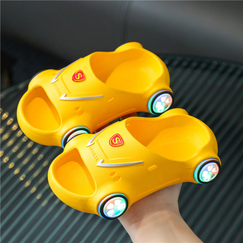 Yellow toy car shoes with green lights on a textured surface