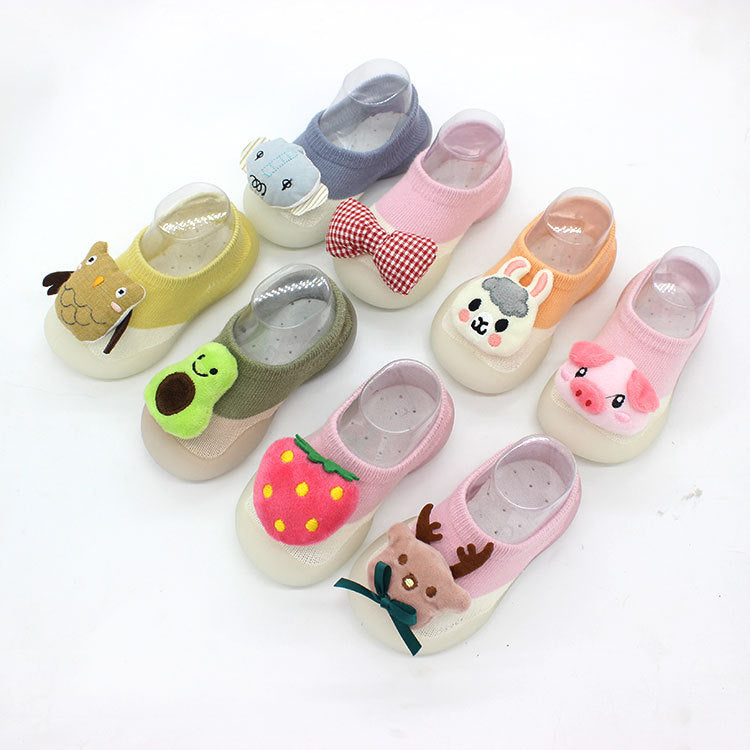 Set of colorful children's shoes with animal and fruit designs on a white background
