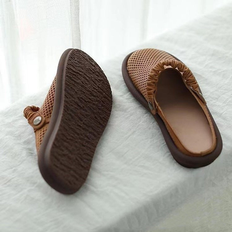 Brown slippers with textured sole on a white background