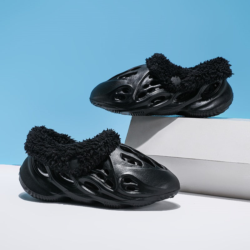 Black sneakers with fuzzy details on a light blue background