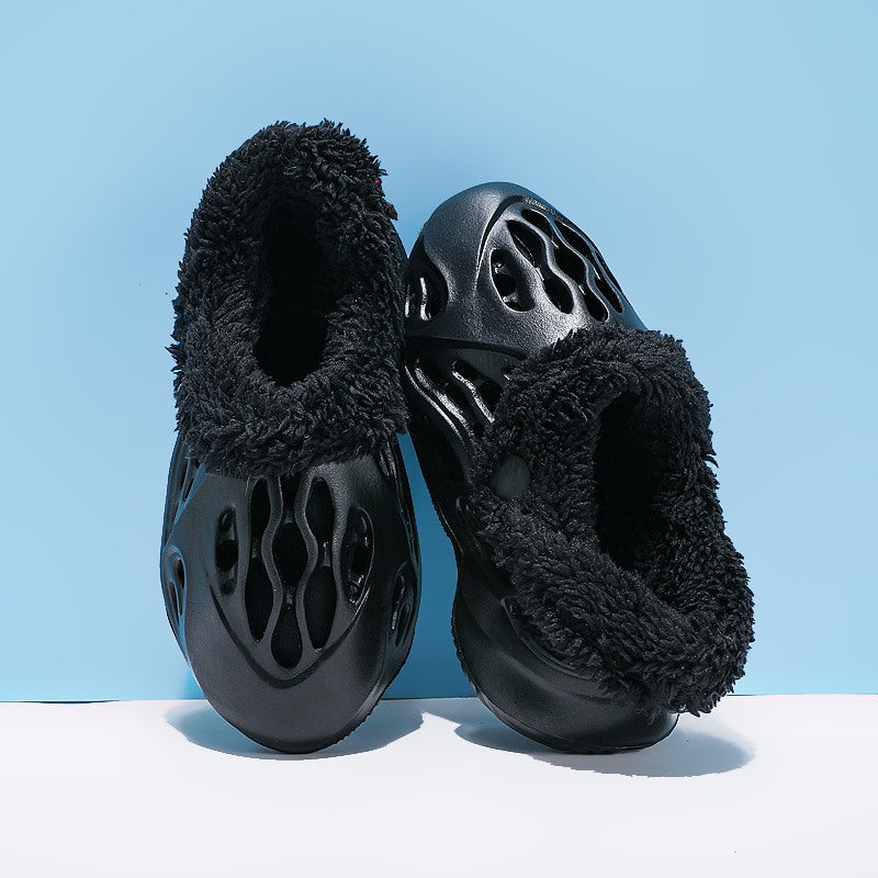 Black slippers with fuzzy texture on a light blue background