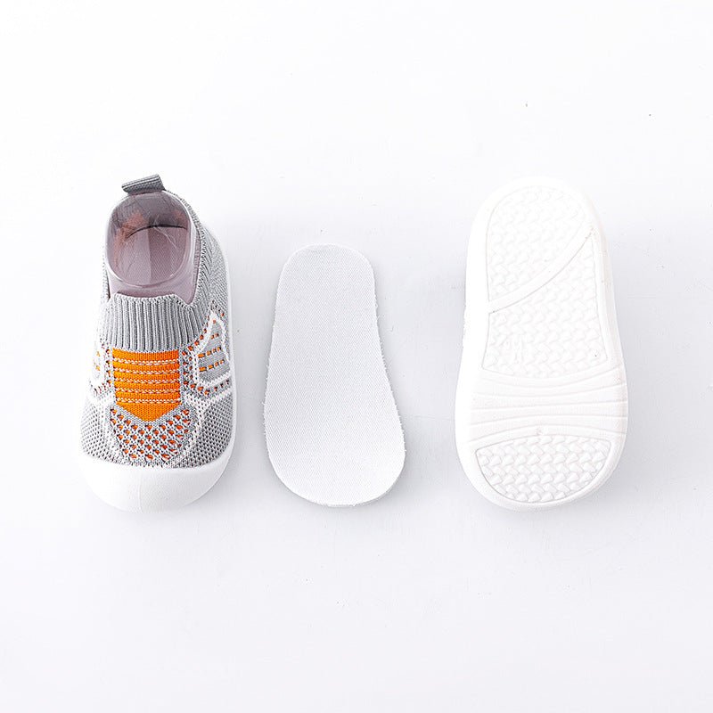 Gray slip-on shoe with orange accents and white sole on a light gray background