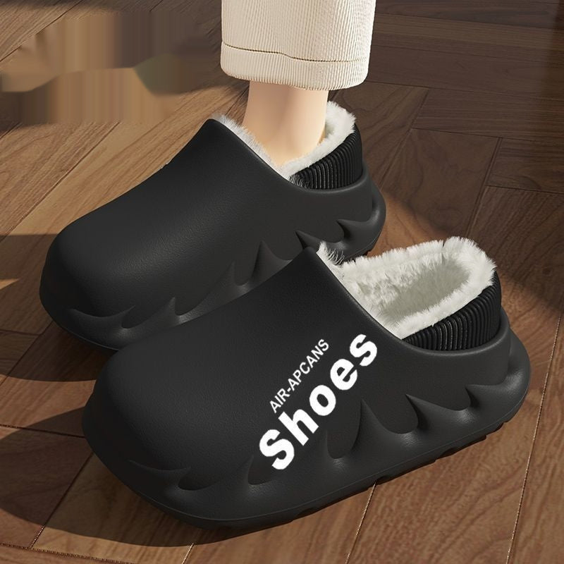 Black slippers with white interior on a wooden floor, featuring the brand 'AIR-APCANS'.