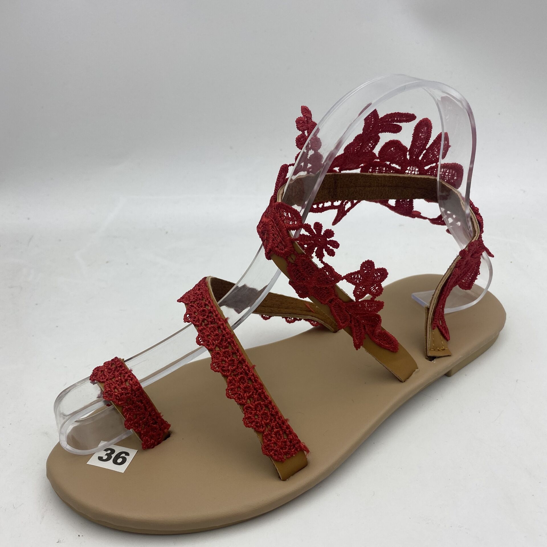 Beige sandal with red floral straps on a white background