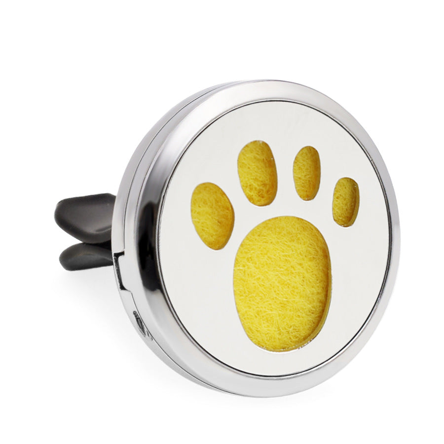 Round metallic car air freshener with yellow paw print design on a white background