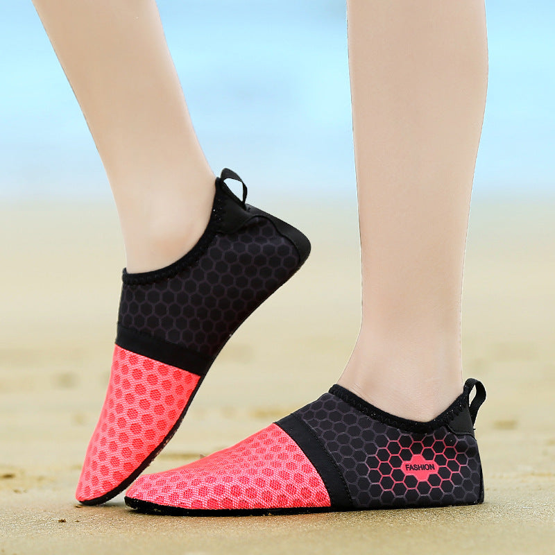Black and pink beach shoes on a sandy background