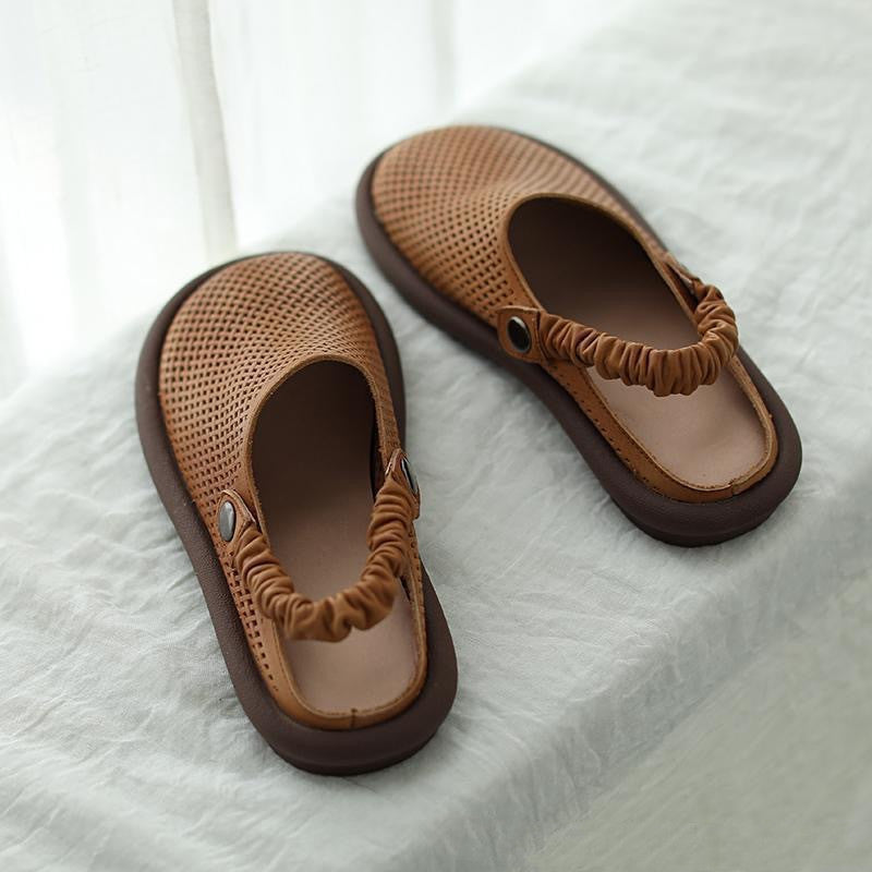 Pair of brown sandals on a white fabric background
