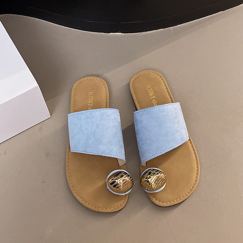 Pair of sandals with light blue straps and gold accents on a beige surface.
