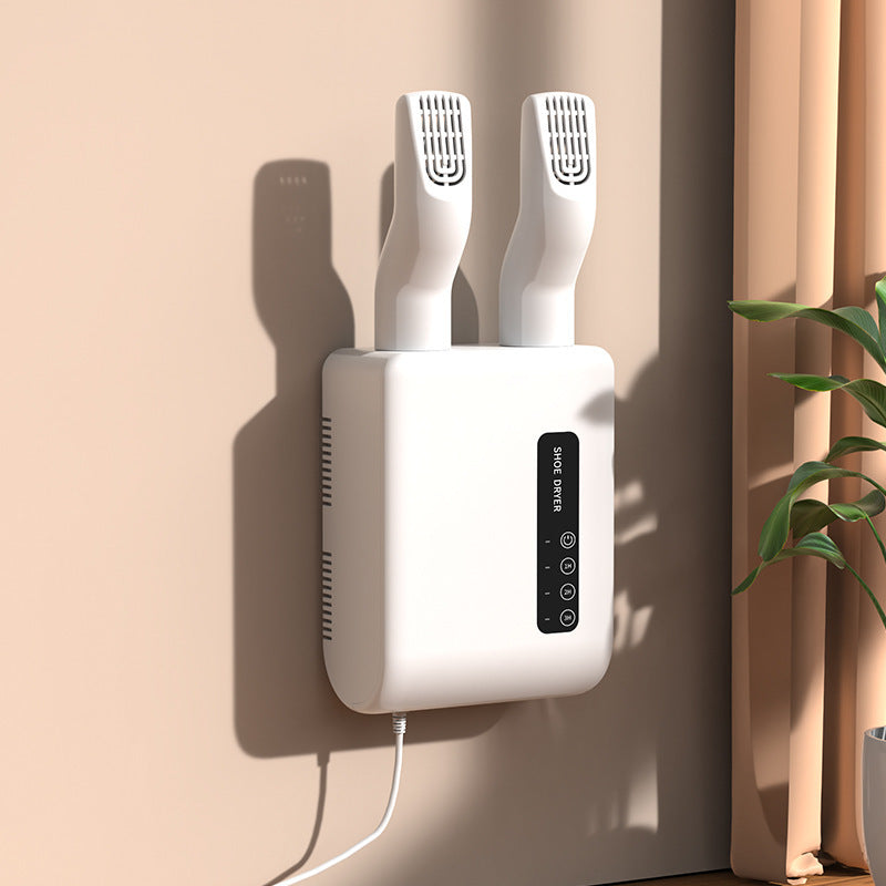White wall-mounted hair dryer with two nozzles on a beige wall.